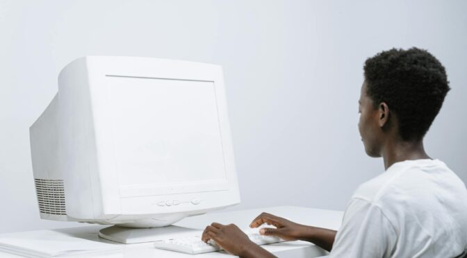 person in white crew neck t shirt using a computer