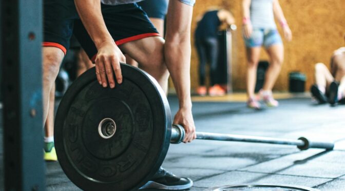 man holding black barbell