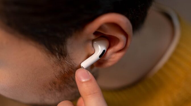 person in yellow sweater wearing an airpods pro