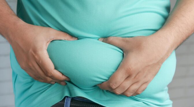 a person holding his belly fat